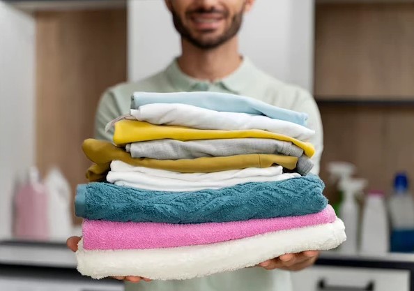 man-holding-pile-clean-clothes_23-2149117026 man-holding-pile-clean-clothes_23-2149117026